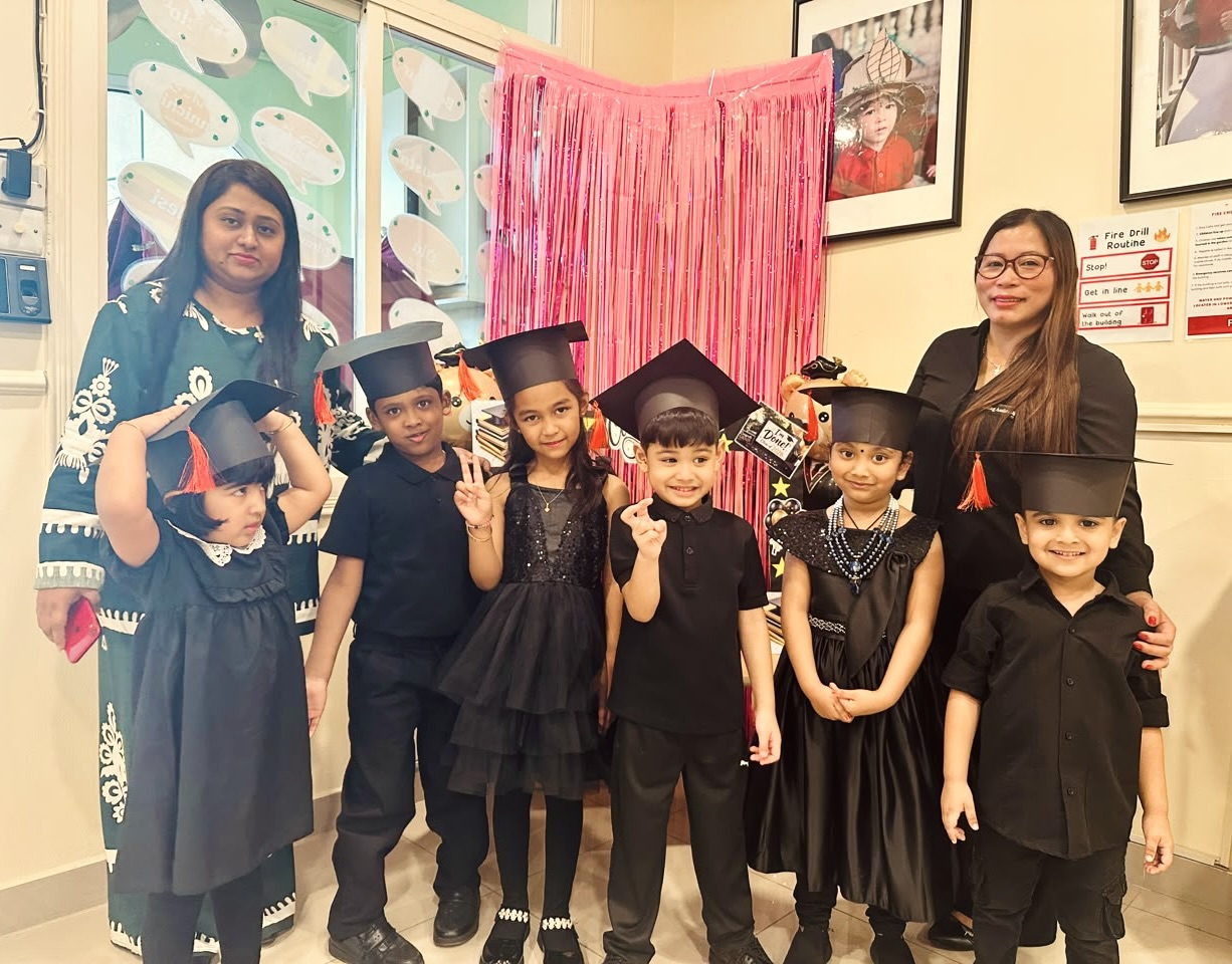 Graduating children in caps and gowns with their teachers