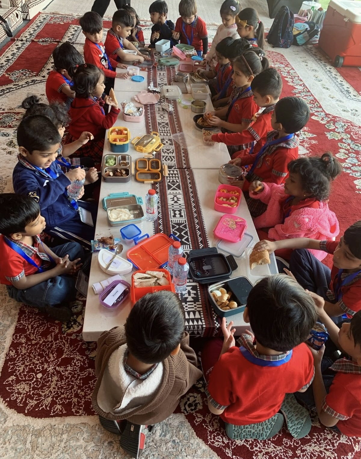 A busy classroom of children working together at low tables