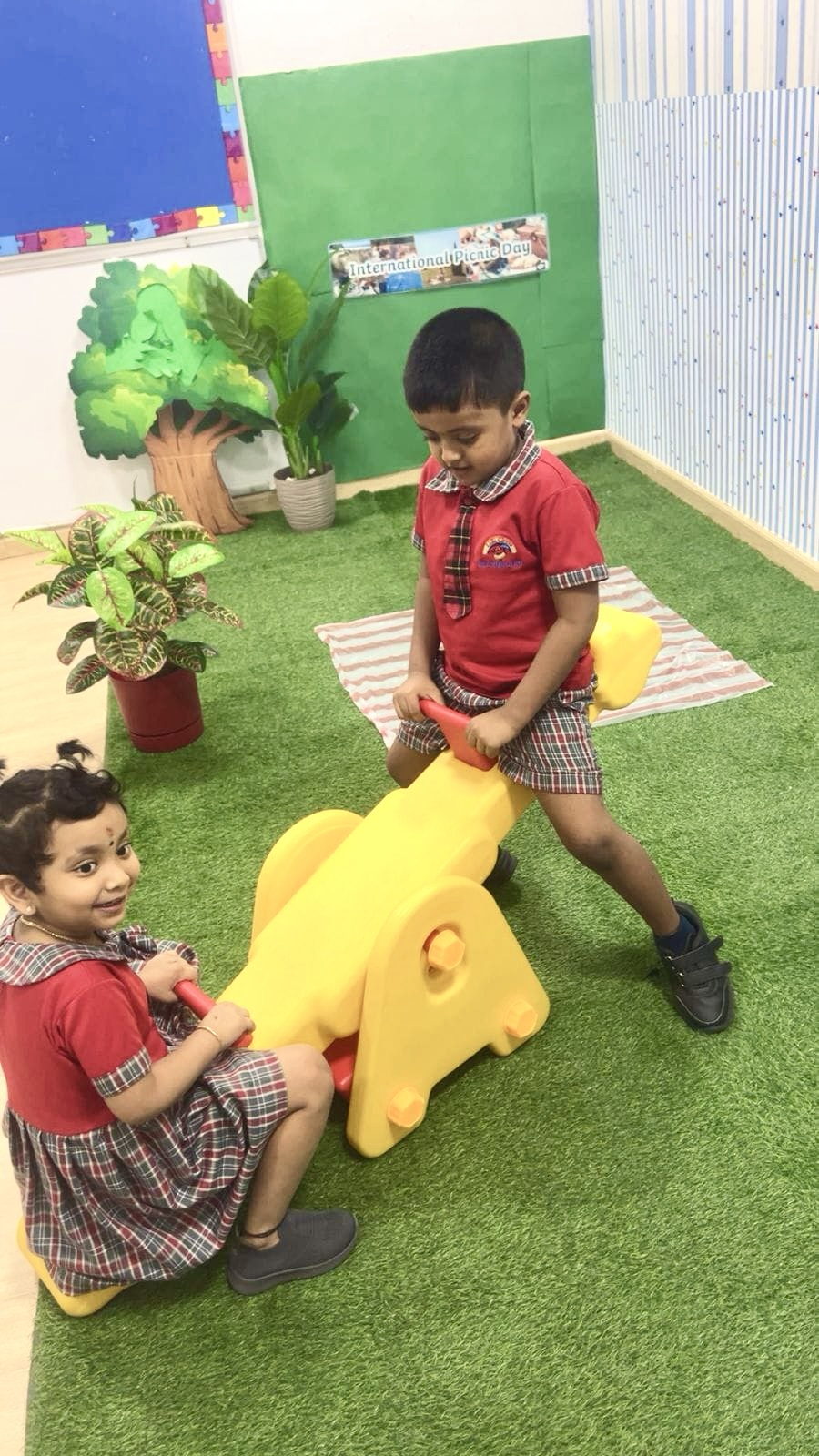 Children playing on ride-on toys in the outdoor garden area